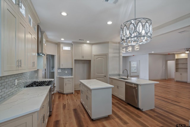 kitchen with stainless steel appliances, hardwood / wood-style flooring, decorative light fixtures, and a center island