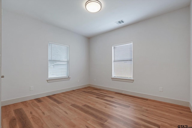 spare room with light hardwood / wood-style flooring and a healthy amount of sunlight