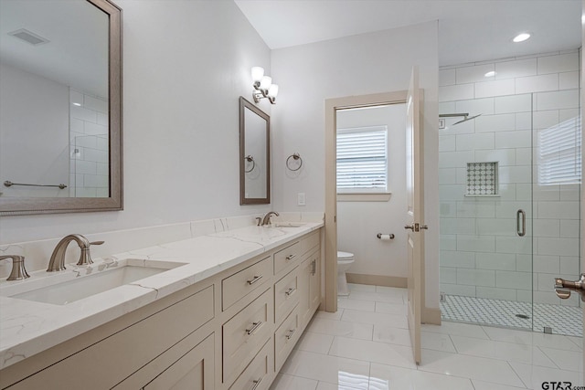 bathroom with toilet, vanity, tile patterned floors, and a shower with shower door