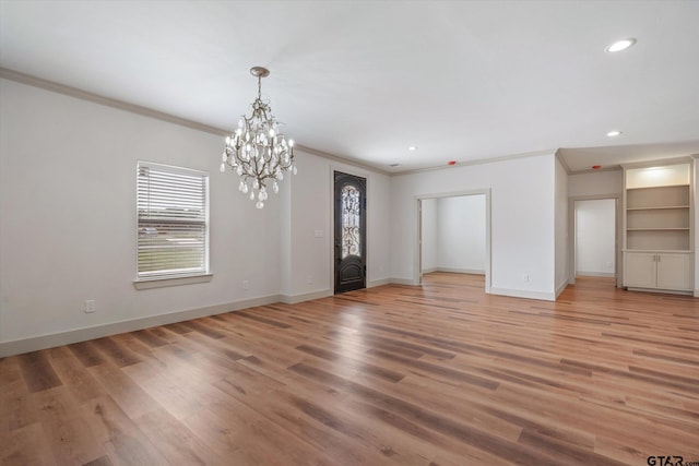 interior space with ornamental molding, wood-type flooring, and a chandelier