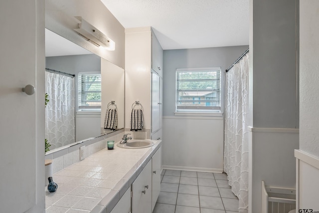 bathroom featuring tile patterned floors, vanity, and baseboards