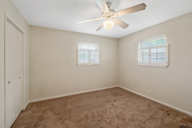 unfurnished bedroom with baseboards, carpet floors, and multiple windows