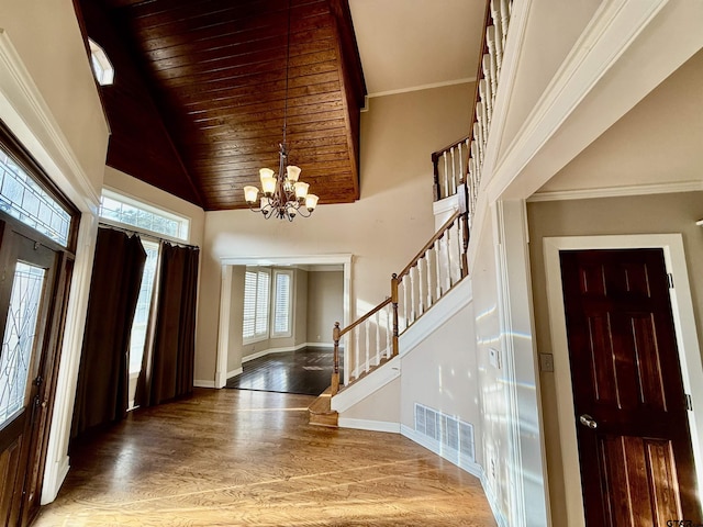 entrance foyer with an inviting chandelier, hardwood / wood-style flooring, high vaulted ceiling, and wooden ceiling