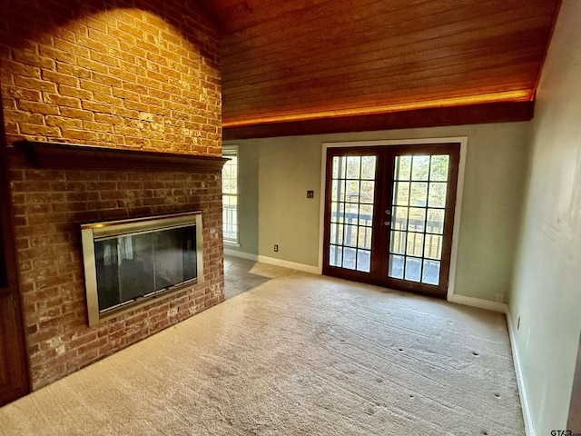 unfurnished living room with french doors, carpet flooring, a brick fireplace, and a wealth of natural light