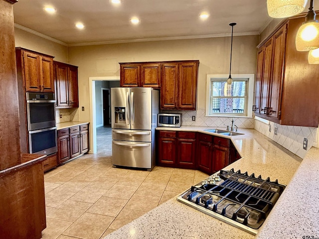 kitchen featuring tasteful backsplash, appliances with stainless steel finishes, sink, and pendant lighting