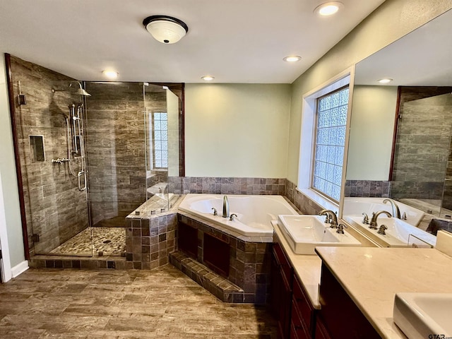 bathroom featuring hardwood / wood-style flooring, shower with separate bathtub, and vanity