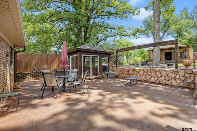 view of patio / terrace with fence, outdoor dining space, and a gazebo