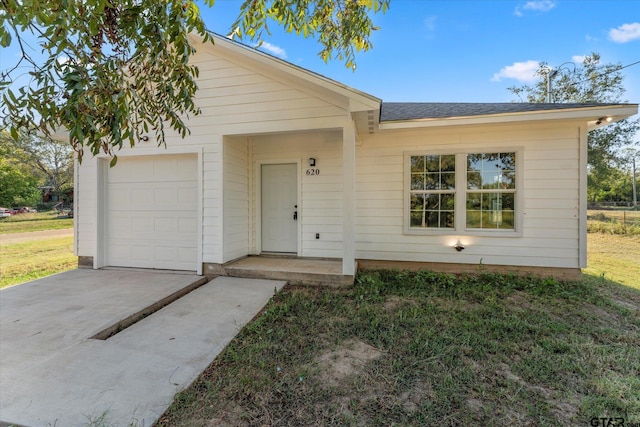 ranch-style house with a garage and a front lawn