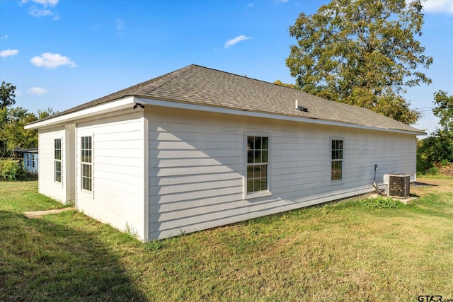 view of side of property featuring a lawn and cooling unit