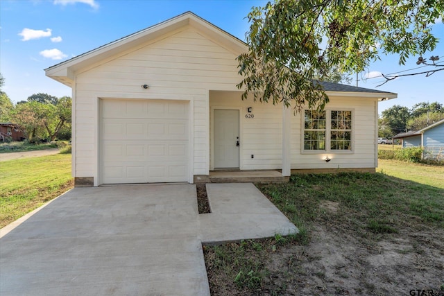 ranch-style home featuring a garage and a front lawn