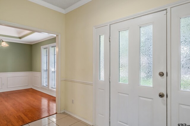 6214 Huntington Dr, Tyler, TX 75703 - entrance foyer with ornamental molding, wainscoting, light tile patterned flooring, and a decorative wall