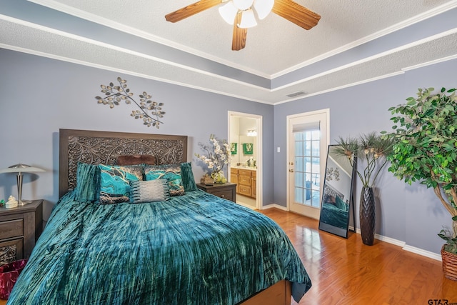 bedroom with wood finished floors, baseboards, ornamental molding, and visible vents
