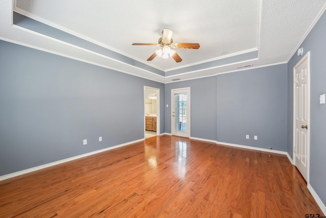 6214 Huntington Dr, Tyler, TX 75703 - spare room featuring a tray ceiling, crown molding, ceiling fan, wood finished floors, and baseboards