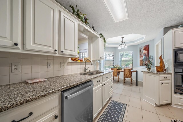 kitchen featuring a raised ceiling, white cabinetry, black appliances, decorative backsplash, and a sink
