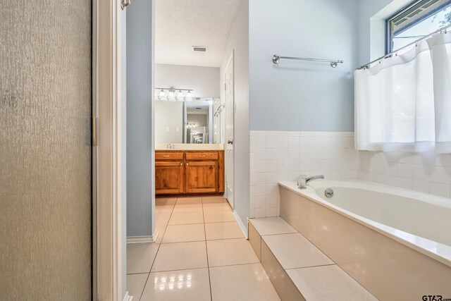 6214 Huntington Dr, Tyler, TX 75703 - bathroom featuring tile patterned flooring, a bath, vanity, a textured ceiling, and a shower