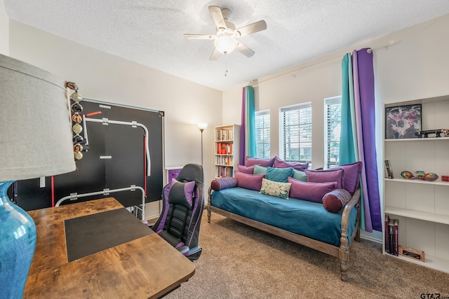carpeted home office featuring a textured ceiling and a ceiling fan