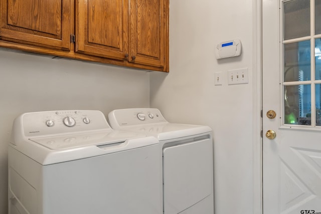 laundry room featuring washing machine and clothes dryer and cabinet space