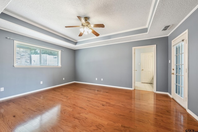 6214 Huntington Dr, Tyler, TX 75703 - unfurnished room with a textured ceiling, crown molding, a tray ceiling, wood finished floors, and ceiling fan