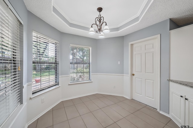 6214 Huntington Dr, Tyler, TX 75703 - unfurnished dining area with a chandelier, a tray ceiling, a textured ceiling, and baseboards