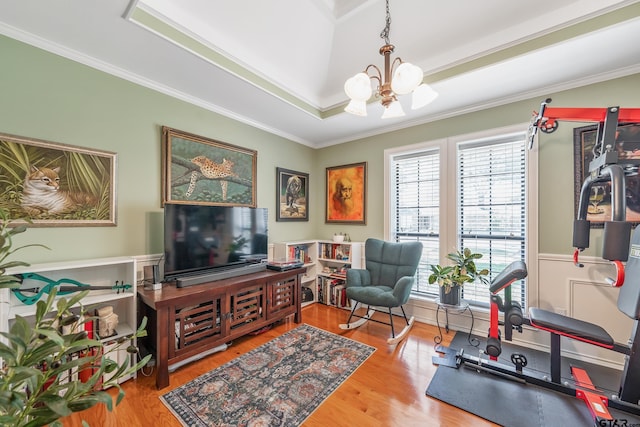 workout room with a chandelier, wood finished floors, and ornamental molding