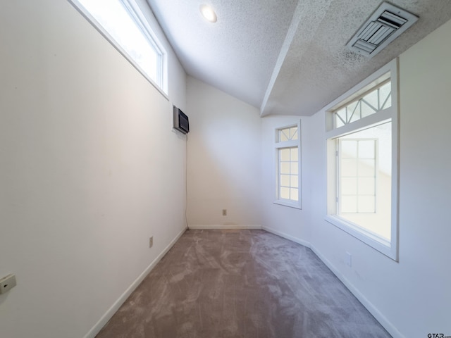 19543 Meadowood Ln, Tyler, TX 75703 - spare room with a textured ceiling, carpet, baseboards, lofted ceiling, and a wall mounted air conditioner