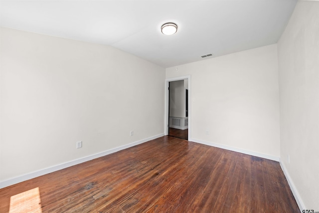 1314 N Queen St, Palestine, TX 75803 - unfurnished room with lofted ceiling, baseboards, visible vents, and dark wood finished floors