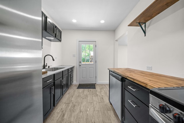 1314 N Queen St, Palestine, TX 75803 - kitchen featuring dark cabinets, butcher block counters, appliances with stainless steel finishes, light wood finished floors, and a sink