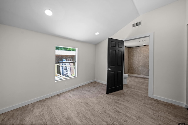 1314 N Queen St, Palestine, TX 75803 - spare room with visible vents, baseboards, vaulted ceiling, and wood finished floors