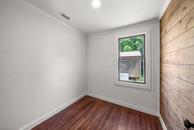 1314 N Queen St, Palestine, TX 75803 - spare room featuring dark wood finished floors, baseboards, visible vents, crown molding, and wooden walls