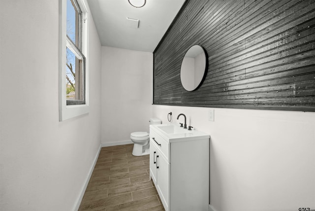 1314 N Queen St, Palestine, TX 75803 - bathroom with toilet, wood finished floors, vanity, and baseboards