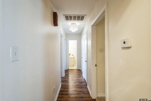 5401 Hollytree Dr, Tyler, TX 75703 - hall with a chandelier, dark wood-style floors, and baseboards