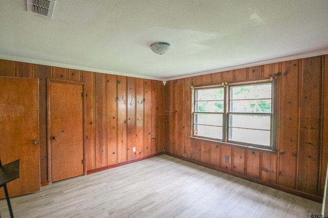 100 Mills St, Arp, TX 75750 - unfurnished bedroom featuring wood finished floors, baseboards, wooden walls, and crown molding