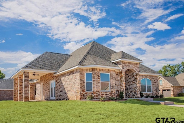 french provincial home featuring brick siding, roof with shingles, and a front yard