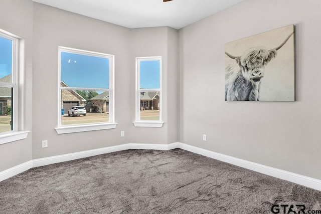 carpeted empty room with baseboards