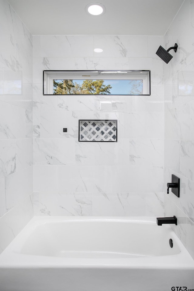 bathroom with tiled shower / bath combo and a wealth of natural light