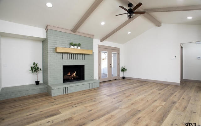 unfurnished living room featuring french doors, vaulted ceiling with beams, light wood-type flooring, ceiling fan, and a fireplace