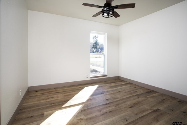 unfurnished room with dark hardwood / wood-style floors and ceiling fan