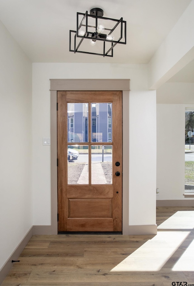 entryway featuring hardwood / wood-style floors and a notable chandelier