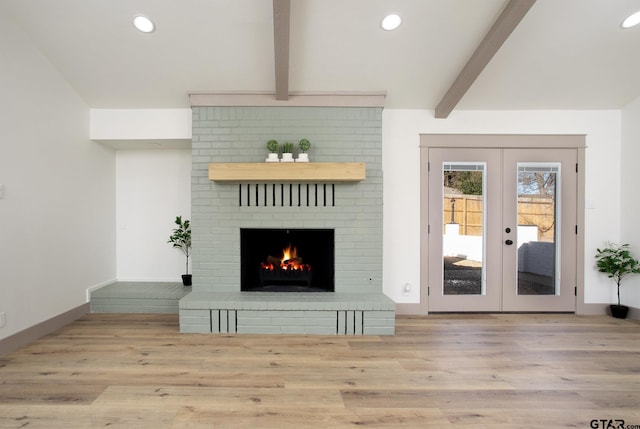 unfurnished living room featuring light hardwood / wood-style floors, a brick fireplace, beam ceiling, and french doors