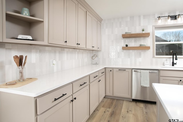 kitchen featuring dishwasher, sink, backsplash, and light hardwood / wood-style flooring