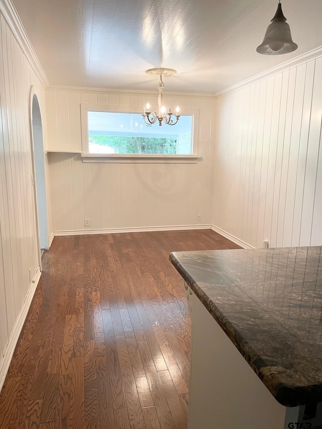 1106 E Redbud, Crockett, TX 75835 - unfurnished dining area with dark wood-style floors, a chandelier, arched walkways, and crown molding