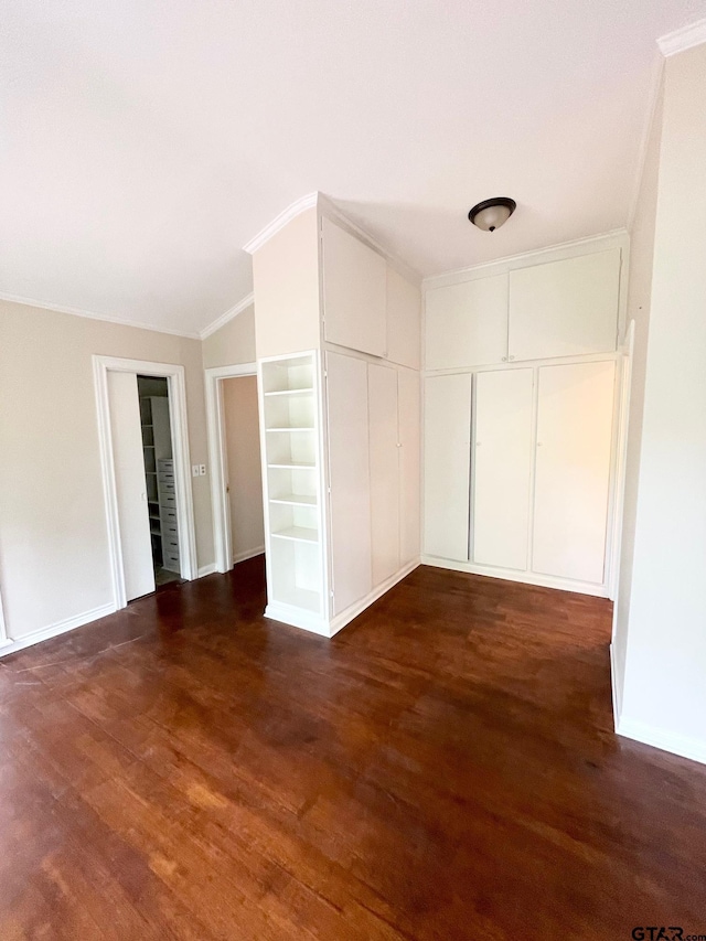 1106 E Redbud, Crockett, TX 75835 - unfurnished bedroom with dark wood-style floors, lofted ceiling, crown molding, and a closet