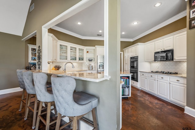 kitchen with decorative backsplash, kitchen peninsula, a kitchen breakfast bar, black appliances, and white cabinets