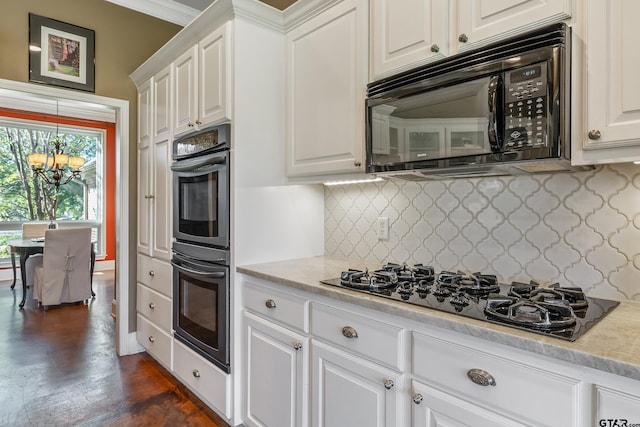 kitchen with decorative backsplash, a chandelier, white cabinets, and black appliances