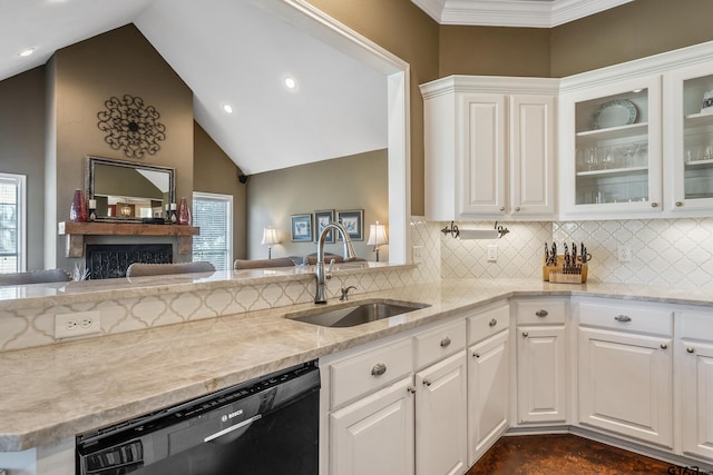 kitchen with white cabinets, sink, black dishwasher, and vaulted ceiling