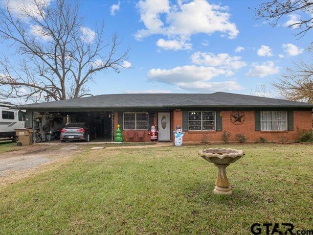 ranch-style home featuring a carport and a front lawn