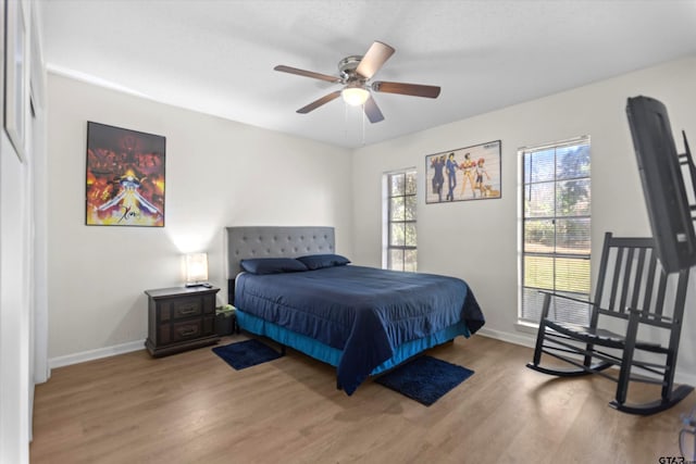 bedroom featuring a ceiling fan, wood finished floors, and baseboards