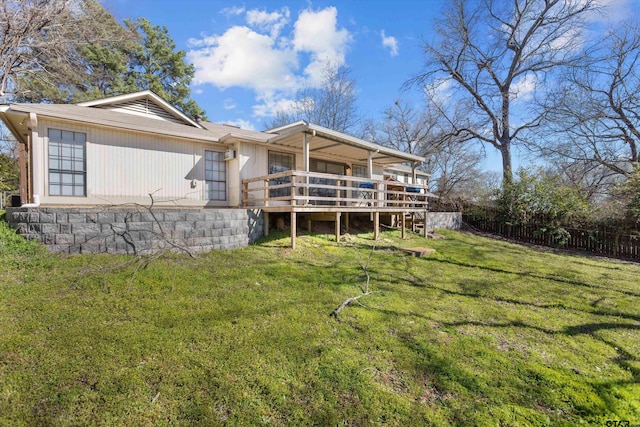 back of house featuring a wooden deck, a lawn, and fence