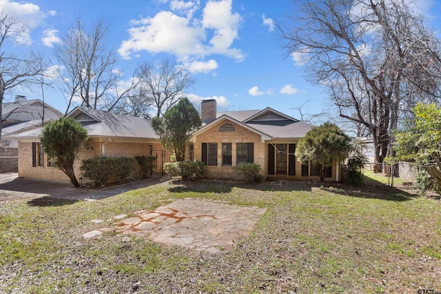 view of front of home featuring a front lawn, fence, brick siding, and a chimney