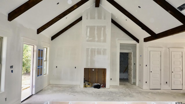 unfurnished living room featuring beamed ceiling and high vaulted ceiling